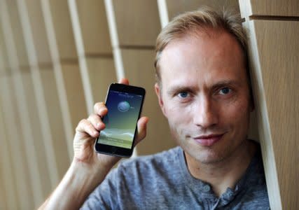 FILE PHOTO: Co-founder of Sweatcoin Oleg Fomenko poses with the app open on a phone at his office in London, Britain May 4, 2016. REUTERS/Paul Hackett/File Photo