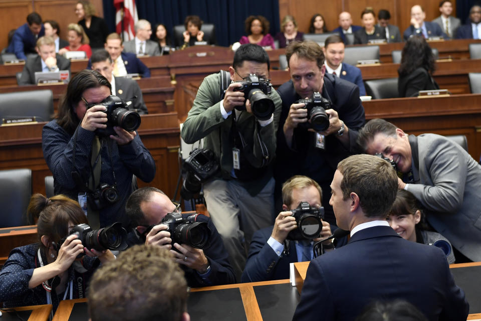 Facebook Chief Executive Officer Mark Zuckerberg, front right, is surrounded by photographers after arriving for a hearing before the House Financial Services Committee on Capitol Hill in Washington, Wednesday, Oct. 23, 2019. (AP Photo/Susan Walsh)