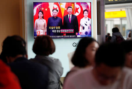 People watch a TV broadcasting a news report on a meeting between North Korean leader Kim Jong Un and Chinese President Xi Jinping in Beijing, in Seoul, South Korea, March 28, 2018. REUTERS/Kim Hong-Ji