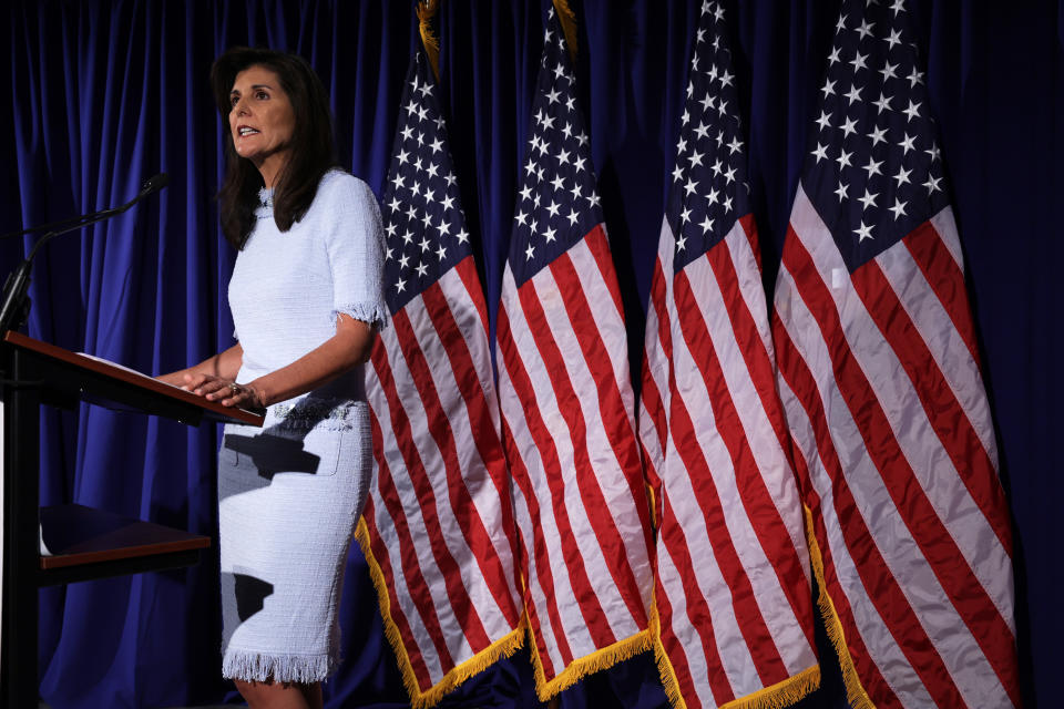 Former South Carolina Gov. Nikki Haley onstage with a row of American flags as a backdrop.