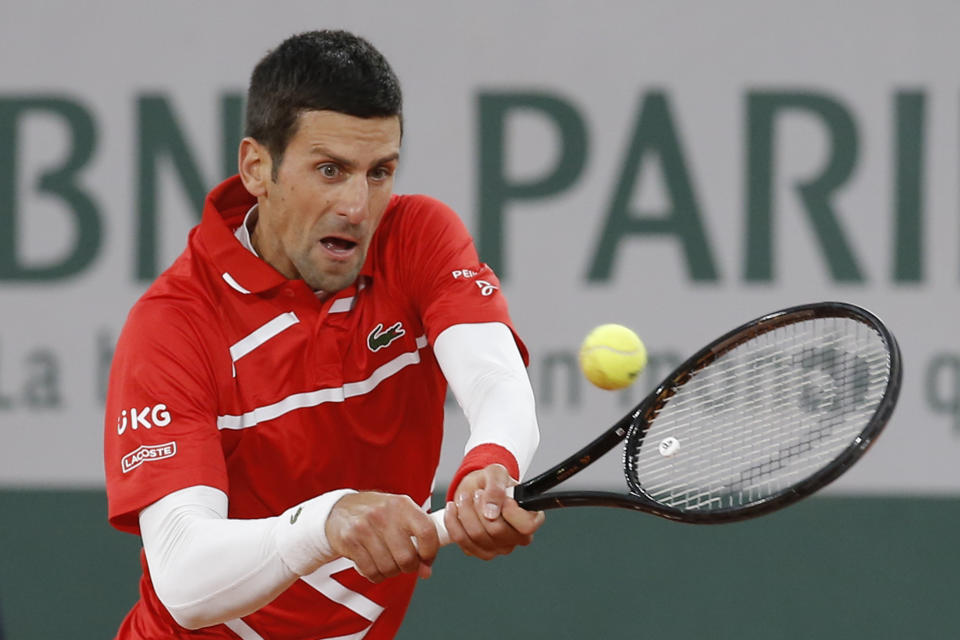 FILE - In this Oct. 11, 2020, file photo, Serbia's Novak Djokovic plays a shot against Spain's Rafael Nadal in the final match of the French Open tennis tournament at the Roland Garros stadium in Paris, France. Djokovic and Rafael Nadal both head into 2021 with some major milestones within reach. Djokovic can surpass Roger Federer’s record for most weeks at No. 1 in the ATP rankings, while Nadal can break his tie with Federer for most Grand Slam singles title for a man, 20. (AP Photo/Michel Euler, File)