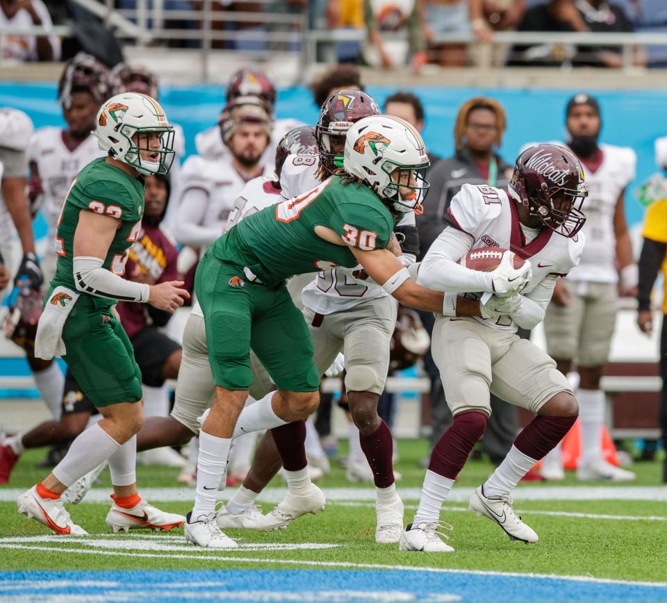 Florida A&M Rattlers defensive back Troy Hilton (30) grabs onto Bethune Cookman Wildcats wide receiver Justyz Tuggle (81) as he tries to tackle him. The Florida A&M Rattlers lead the Bethune Cookman Wildcats 13-7 at the half during the Florida Classic at Camping World Stadium on Saturday, Nov. 20, 2021.