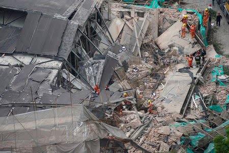 Firefighters work at the site where a building collapsed, in Shanghai, China May 16, 2019. REUTERS/Aly Song