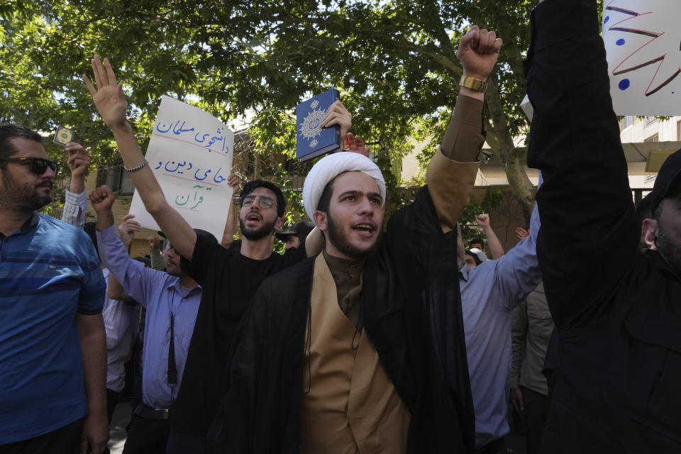 A clergyman chants slogan during a protest of the burning of a Quran in Sweden, in front of the Swedish Embassy in Tehran, Iran, Friday, June 30, 2023. On Wednesday, a man who identified himself in Swedish media as a refugee from Iraq burned a Quran outside a mosque in central Stockholm. The placard at rear reads in Persian: "Muslim student is supporter of the religion and Quran". (AP Photo/Vahid Salemi)