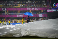 Officials inspect the playing field as the rain delayed the start of the Indian Premier League cricket match between Rajasthan Royals and Kolkata Knight Riders in Guwahati, India, Sunday, May. 19, 2023. (AP Photo/Anupam Nath)