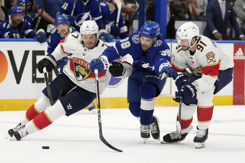 Tampa Bay Lightning left wing Brandon Hagel (38) gets sandwiched by Florida Panthers defenseman Dmitry Kulikov (7) and defenseman Oliver Ekman-Larsson (91) during the second period in Game 4 of an NHL hockey Stanley Cup first-round playoff series, Saturday, April 27, 2024, in Tampa, Fla. (AP Photo/Chris O'Meara)