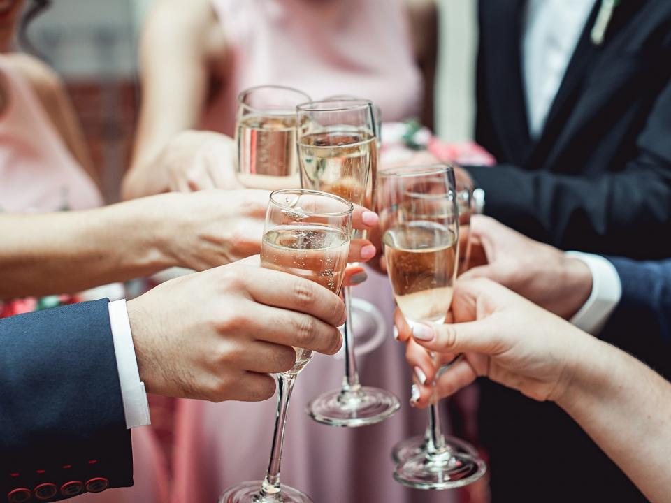 Wedding guests clink glasses of Champagne together