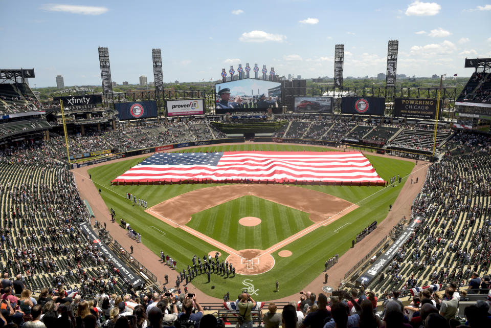 FILE - In this July 4, 2019, file photo, an American Flag is unfurled in the outfield during the playing of the National Anthem before the start a baseball game between the Chicago White Sox and the Detroit Tigers in Chicago. Major League Baseball owners gave the go-ahead Monday, May 11, 2020, to making a proposal to the players’ union that could lead to the coronavirus-delayed season starting around the Fourth of July weekend in ballparks without fans, a plan that envisioned expanding the designated hitter to the National League for 2020. (AP Photo/Mark Black, File)