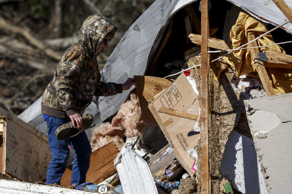 John Henderson, helps sift through debris looking for personal items as they recover from a tornado that ripped through Central Alabama earlier this week Saturday, Jan. 14, 2023 in Marbury, Ala.. Stunned residents tried to salvage belongings as rescue crews pulled survivors from the aftermath of a deadly tornado-spawning storm system. (AP Photo/Butch Dill)