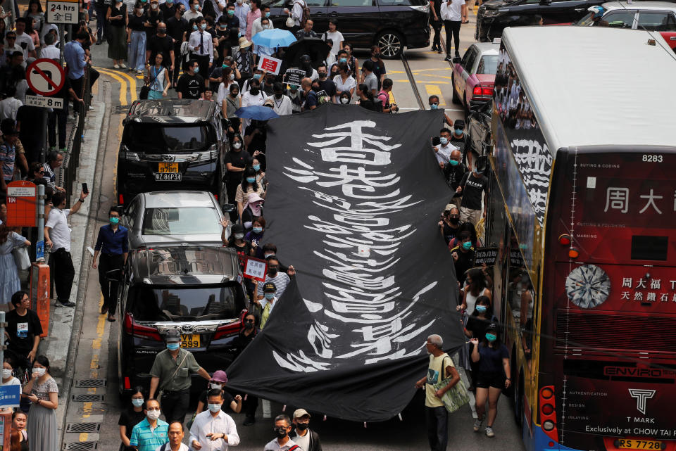 People hold up a banner as they march to protest against what they say is the abuse of pro-democracy protesters by Hong Kong police, at Chater Garden in Central district, Hong Kong, China October 11, 2019. REUTERS/Susana Vera     TPX IMAGES OF THE DAY
