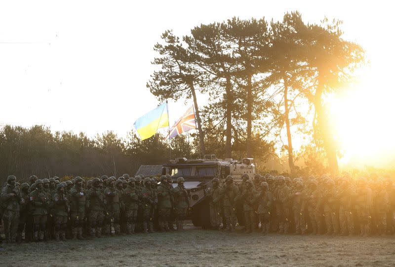 Ukrainian military recruits take part in ceremony to mark the first anniversary of the Russian invasion of Ukraine at a military base in Britain