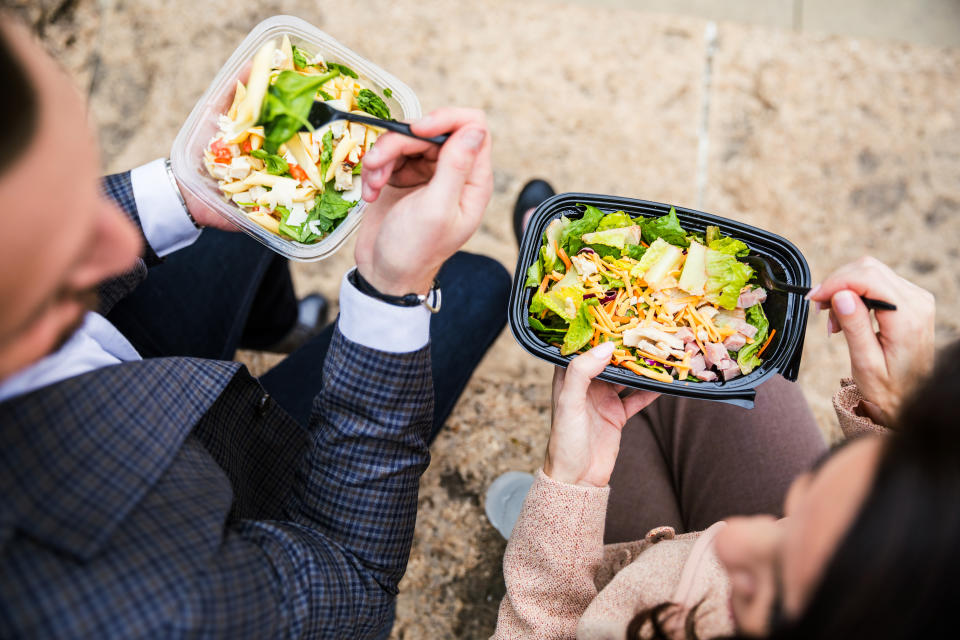 Couple of business people outside the office buildings in downtown waiting for a meeting in Chicago, USA. Having a lunch break together during a working day.