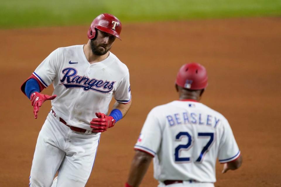 Texas Rangers’ Joey Gallo, left, celebrates with third base coach Tony Beasley (27) after hitting a three-run home run off of Arizona Diamondbacks’ Taylor Widener during the fourth inning of a baseball game in Arlington, Texas, Tuesday, July 27, 2021. (AP Photo/Tony Gutierrez)