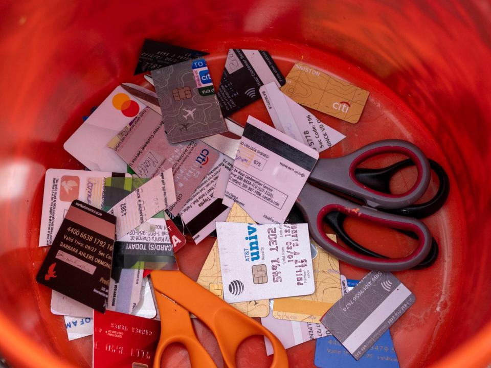 inside orange bucket with scissors and cut up credit cards