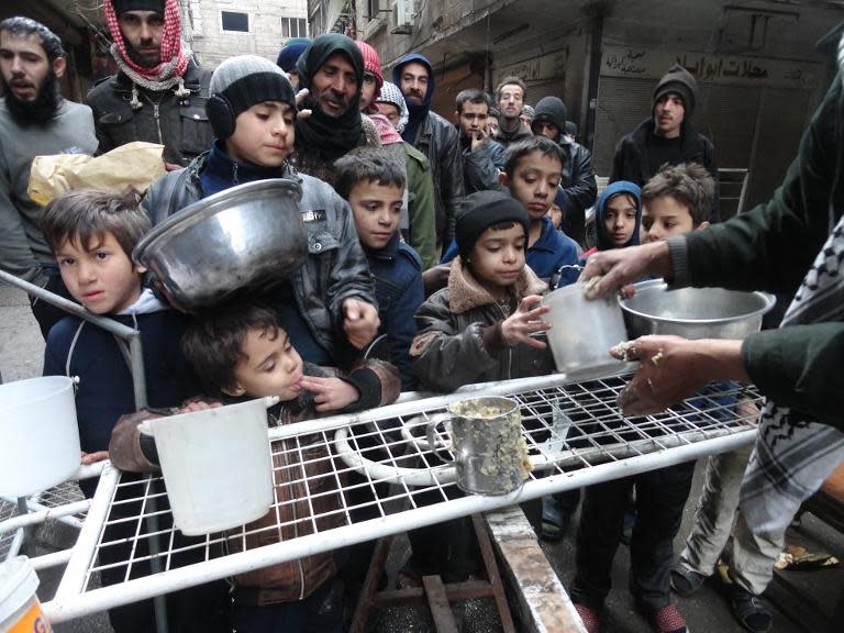 Residents of the besieged Palestinian refugee camp of Yarmuk in Damascus collect aid food at the adjacent Jazira neighborhood on February 13, 2015