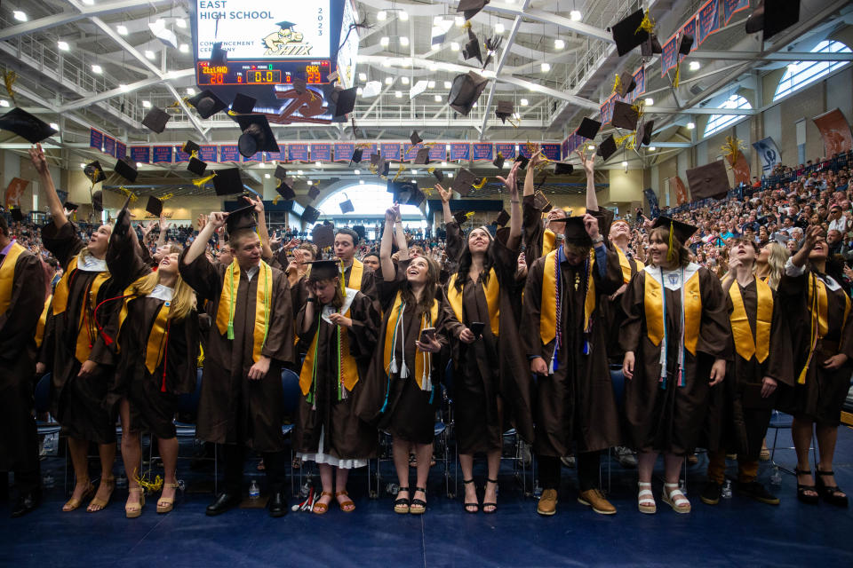 Graduates from Zeeland East High School throw their caps in the air during their commencement ceremony Thursday, May 25, 2023, at DeVos Fieldhouse in Holland.