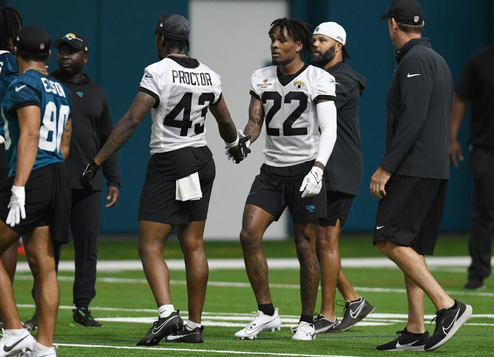 Jacksonville Jaguars safety Josh Proctor and teammate Jaguars cornerback Jarrian Jones (22) slap hands between drills at Friday's rookie minicamp. The Jacksonville Jaguars held their first day of rookie minicamp inside the covered field at the Jaguars performance facility in Jacksonville, Florida Friday, May 10, 2024.