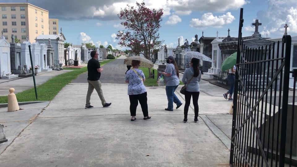 Tourists wander through a historic New Orleans cemetery on Thursday, Aug. 12, 2021. The city’s vital tourism industry was devastated by the COVID-19 epidemic in 2020. It had begun making a comeback in recent months as vaccines have become available. But the spread of the highly contagious delta variant of the coronavirus and a low vaccination rate in Louisiana are being blamed for a resurgence of COVID-19 that has stressed hospitals and led to cancellations, for the second year, of tourist-drawing events. (AP Photo/Kevin McGill)