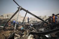 Workers salvage oil canisters from the wreckage of a vehicle oil store hit by Saudi-led airstrikes in Sanaa, Yemen, Thursday, July 2, 2020. (AP Photo/Hani Mohammed)