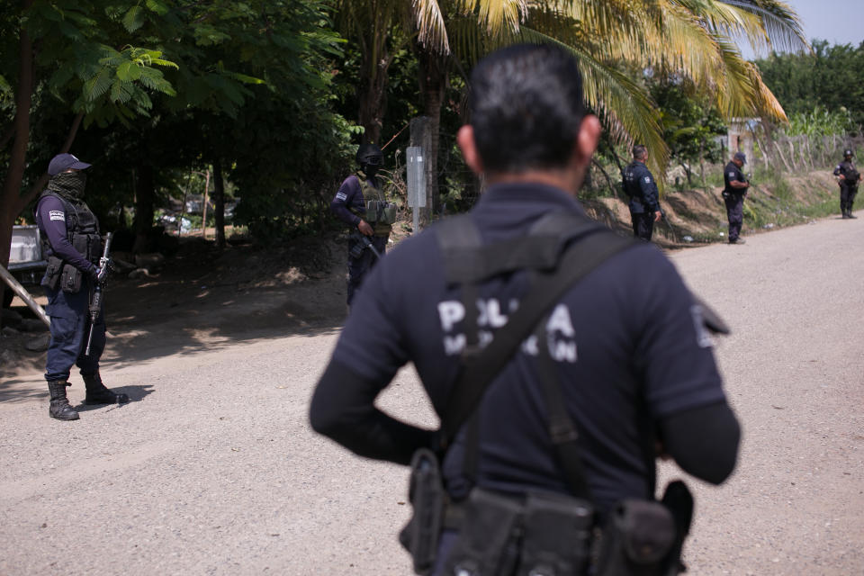 Mexican police man at a check point after a clash between armed groups in Tepalcatepec, Michoacan state, Mexico, Saturday, Aug. 31, 2019. Heavily armed bands clashed Friday in Tepalcatepec, leaving at least 9 dead, according to authorities. (AP Photo/Armando Solis)