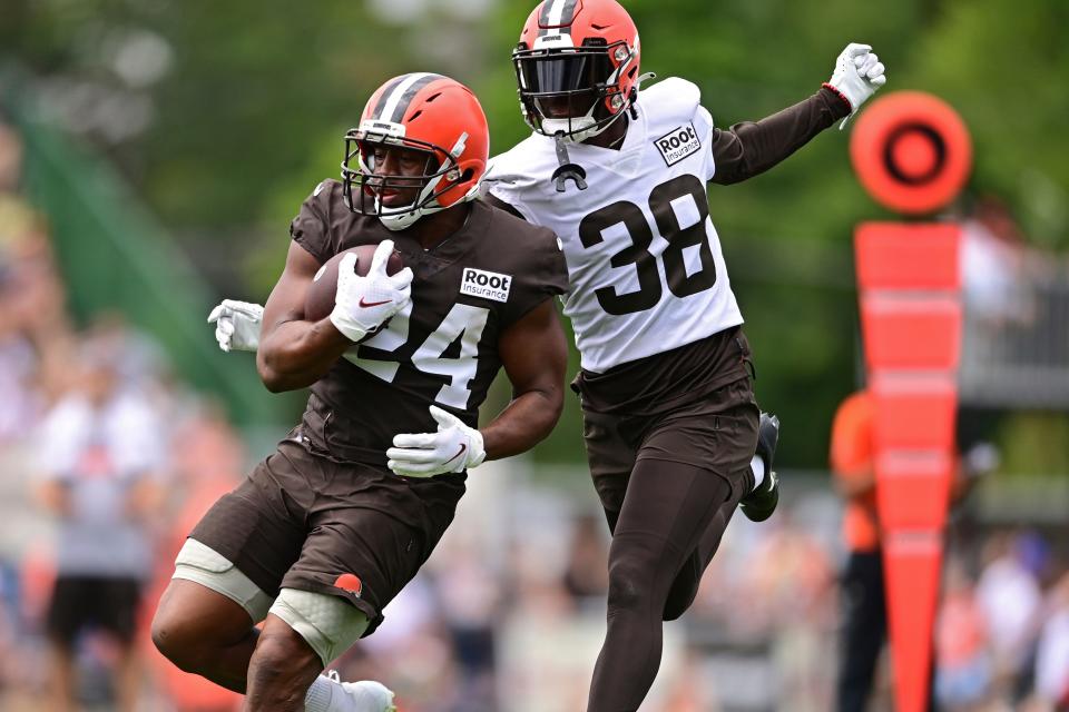 Cleveland Browns running back Nick Chubb, left, runs while being hit by cornerback A.J. Green during NFL football practice in Berea, Ohio, Tuesday, Aug. 16, 2022. (AP Photo/David Dermer)