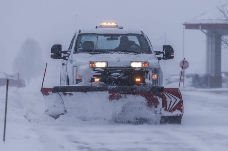 A truck with a snow plow clears a snow-packed roadway as a winter storm makes travel dangerous in Altoona, Iowa, on Friday. The National Weather Service in Des Moines, Iowa, cautioned drivers to stay off the roads, even as they prepare for the Iowa Republican Caucus on Monday. Photo by Tannen Maury/UPI