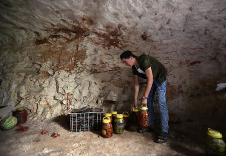 A man holds pickled vegetables in an underground cave in Idlib, Syria September 3, 2018. Picture taken September 3, 2018. REUTERS/Khalil Ashawi