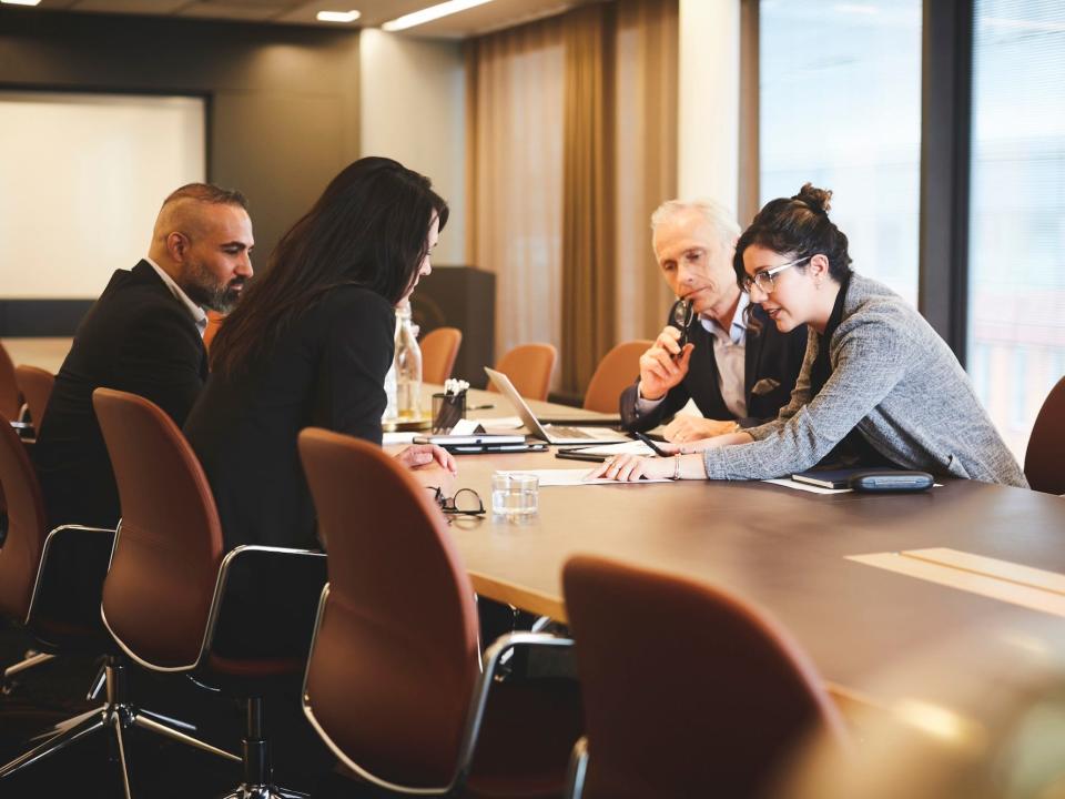 Lawyers sitting at a table and looking at a document