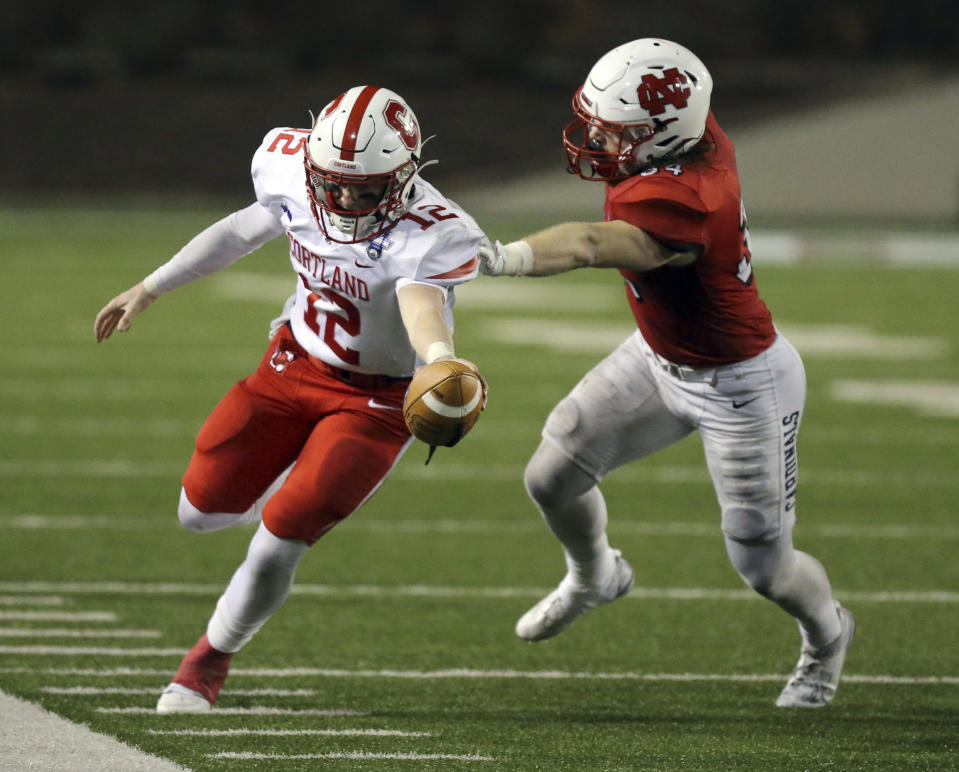 Cortland quarterback Zac Boyes (12) stretches for a first down past North Central defender BJ Adamchik (34) during the second half of the Amos Alonzo Stagg Bowl NCAA Division III championship football game in Salem, Va., Friday Dec. 15, 2023. (Matt Gentry/The Roanoke Times via AP)