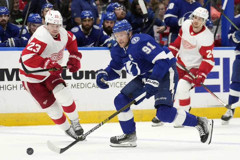 Tampa Bay Lightning center Steven Stamkos (91) splits between Detroit Red Wings left wing Lucas Raymond (23) and center Pius Suter (24) during the second period of an NHL hockey game Thursday, April 13, 2023, in Tampa, Fla. (AP Photo/Chris O'Meara)