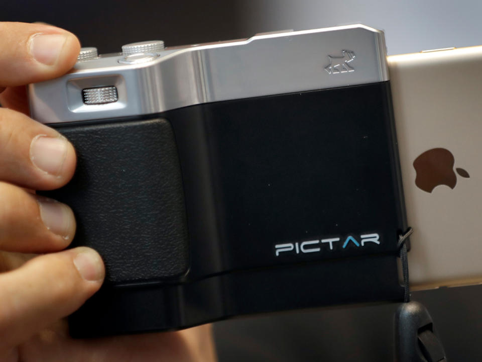 Mit dem Miggo-Pictar-Griff wird das Handy zu einer Art DSLR-Kamera. (Bild-Copyright: Michael Sohn/AP Photo)