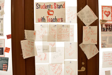 A state representative's door is covered in notes from teachers that were at the state Capitol on the second day of a teacher walkout to demand higher pay and more funding for education in Oklahoma City, Oklahoma, U.S., April 3, 2018. REUTERS/Nick Oxford