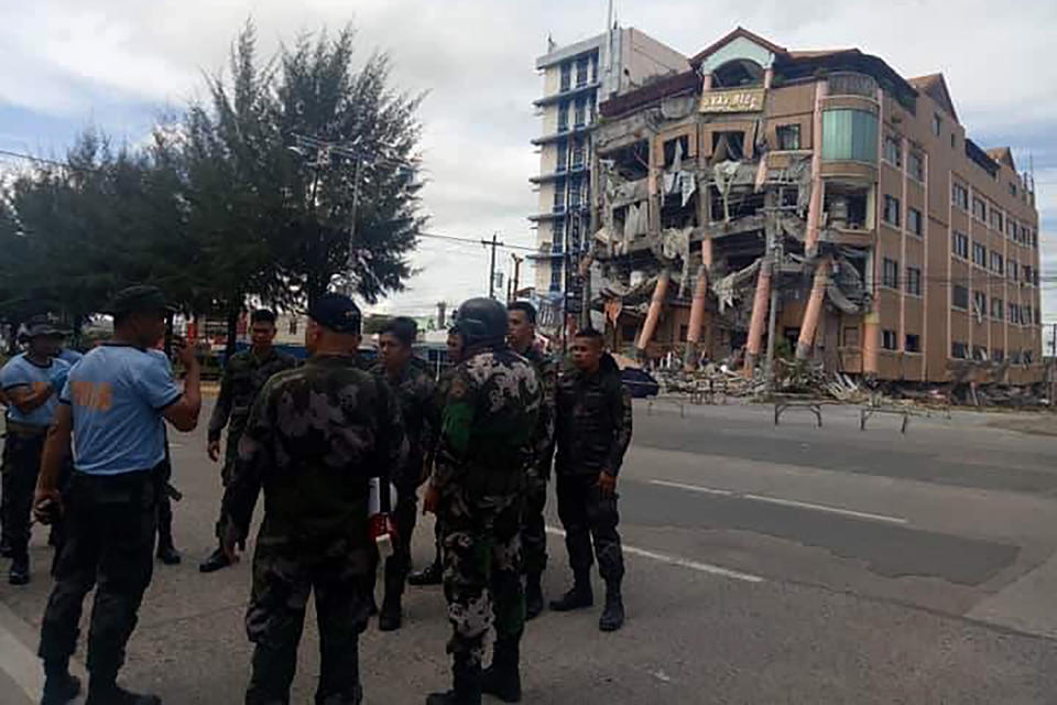 Police secure the area near Eva's Hotel, right, damaged after a strong earthquake in Kidapawan, north Cotabato province, Philippines, Thursday, Oct. 31, 2019. The third strong earthquake this month jolted the southern Philippines on Thursday morning, further damaging structures already weakened by the earlier shaking. (AP Photos/Williamor Magbanua)