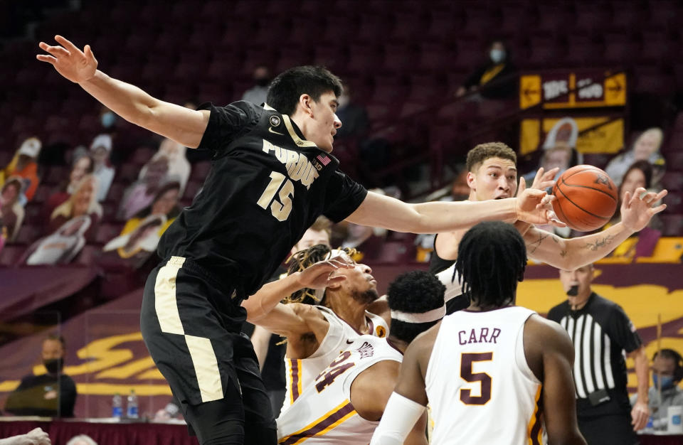 Purdue's Zach Edey (15) makes a pass to Mason Gillis, top right, amidst Minnesota defenders in the second half of an NCAA college basketball game, Thursday, Feb. 11, 2021, in Minneapolis. (AP Photo/Jim Mone)