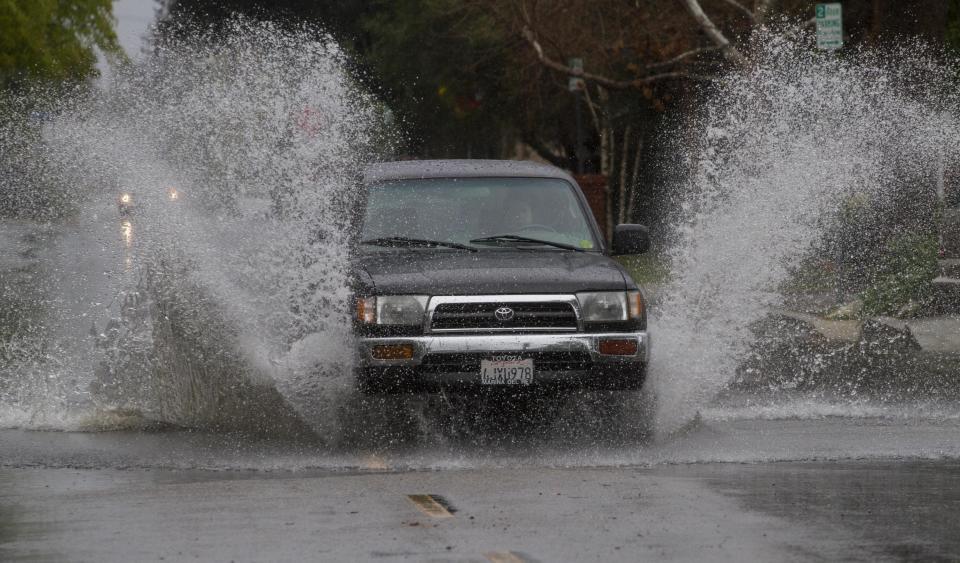 A SUV drives through a flooded portion of a street in Encino, section of Los Angeles Friday, Feb. 28, 2014. (AP Photo/Ringo H.W. Chiu)