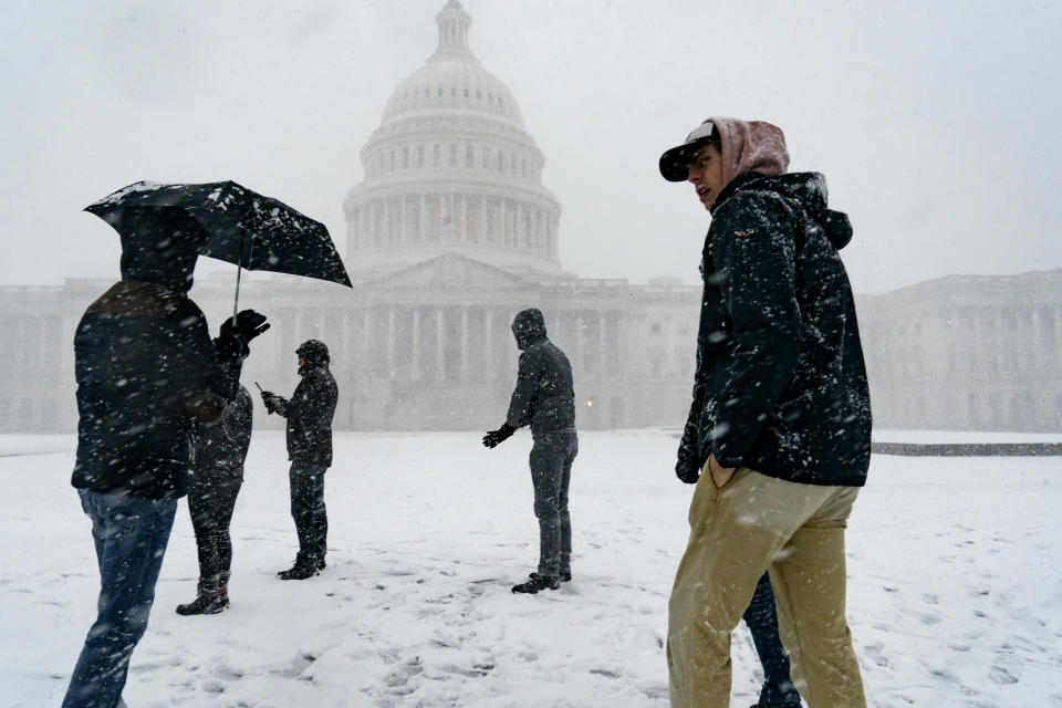 Visitors from France enjoy the scenery as a winter storm delivers heavy snow to the Capitol in Washington, Monday, Jan. 3, 2022. (AP Photo/J. Scott Applewhite)