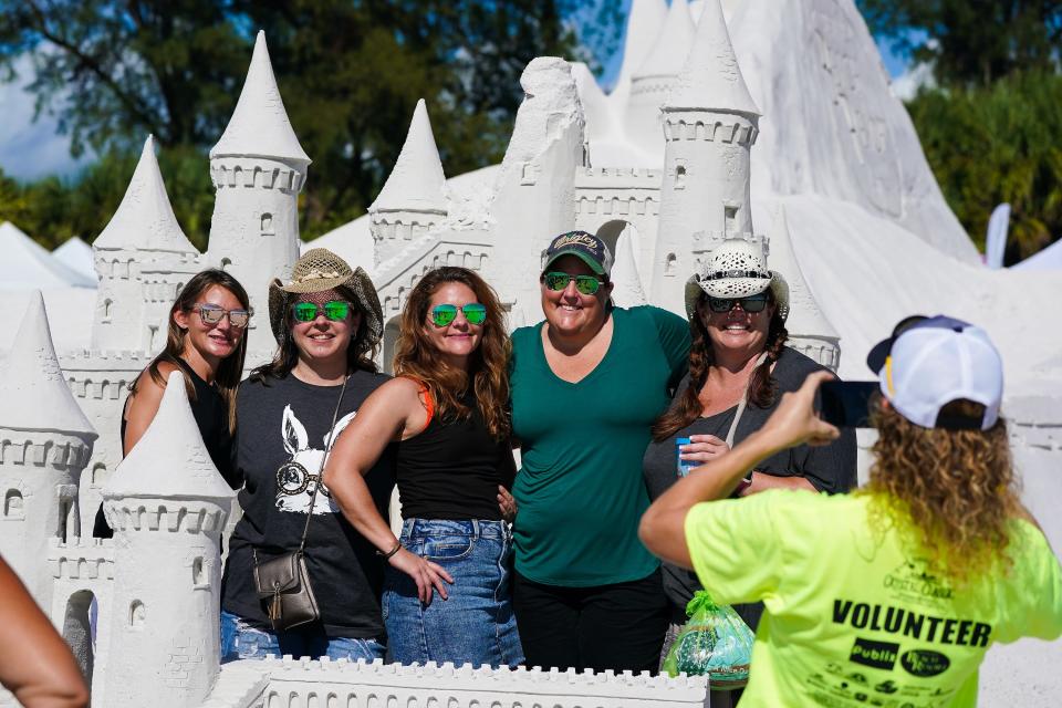 A group on vacation from Waterloo, Illinois, gets their photo taken by at the Crystal Classic International Sand Sculpting Festival.