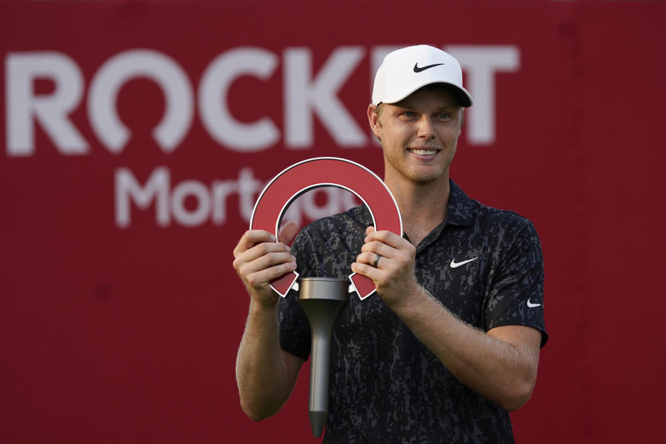 FILE - Cam Davis of Australia holds the winner's trophy after the final round of the Rocket Mortgage Classic golf tournament, Sunday, July 4, 2021, at the Detroit Golf Club in Detroit. The Rocket Mortgage Classic in Detroit features five of the top 20 players a field that appears to be stronger than the one at the Golf series this week in New Jersey. (AP Photo/Carlos Osorio, File)