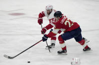 Detroit Red Wings defenseman Jordan Oesterle (82) and Florida Panthers center Eetu Luostarinen (27) go for the puck during the third period of an NHL hockey game, Thursday, Dec. 8, 2022, in Sunrise, Fla. The Panthers won 5-1. (AP Photo/Lynne Sladky)