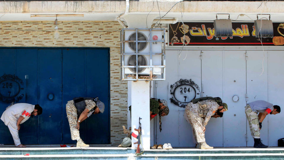 Libyan forces pray in Sirte