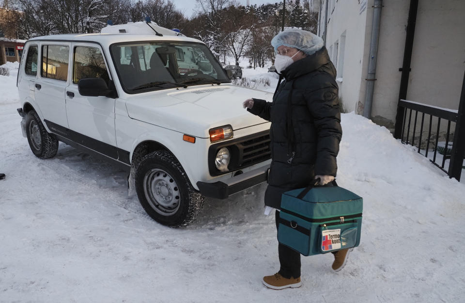 A medical worker carries a thermal bag with vaccines from a clinic in Lakhdenpokhya to drive to Ikhala, one of several remote villages in the village of Ikhala in Russia’s Karelia region, Tuesday, Feb. 16, 2021. Russia’s rollout of its coronavirus vaccine is only now picking up speed in some of its more remote regions, although experts say the campaign is still moving slowly. (AP Photo/Dmitri Lovetsky)