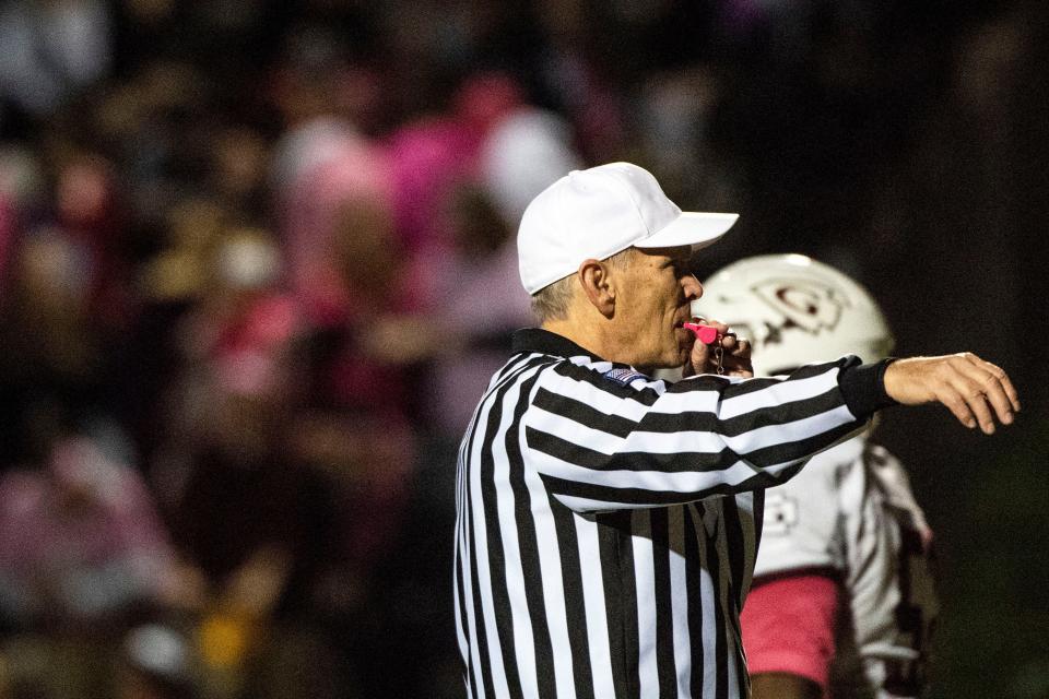 Blowing a pink whistle in observance of breast cancer awareness month, a referee calls a play to an end, Friday, Oct. 19, 2018. The Gettysburg Warriors secured the YAIAA Division II title with a win over the Dover Eagles, 28-7, thanks to a huge second-half comeback.Friday, Oct. 19, 2018. The Gettysburg Warriors secured the YAIAA Division II title with a win over the Dover Eagles, 28-7, thanks to a huge second-half comeback.