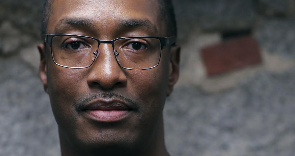 In this Tuesday June 4, 2019 photograph, Sean Ellis poses for a photo at the law office of his attorney Rosemary Scapicchio in Boston. During the 22 years he spent in prison after being convicted of killing a Boston police detective, Ellis believed there was something suspicious about the officers who led the murder investigation. He just couldn’t prove it. It would take years of digging and scores of public information requests from his attorneys to uncover evidence that several officers investigating the 1993 murder case were involved in criminal activity, information that wasn’t shared with the defense. (AP Photo/Charles Krupa)