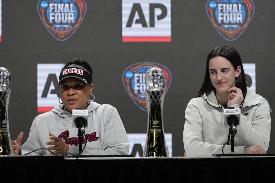 Kaitlyn Clark vom US-Bundesstaat Iowa hört zu, wie Dawn Staley, Cheftrainerin des US-Bundesstaates South Carolina, während einer Pressekonferenz zur Bekanntgabe der Auszeichnungen „Trainer des Jahres“ und „Spieler des Jahres“ der AP NCAA am Donnerstag, dem 4. April 2024, in Cleveland spricht.  (AP Photo/Maury Gash)