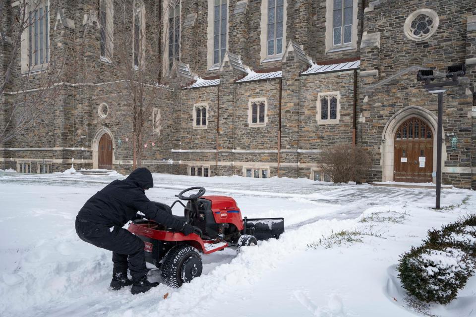 Mark Dahnke, the grounds superintendent for The First Congregational Church from Grove City, pulls a lawn mower with a snowplow attached to it out of a pile of snow while clearing sidewalks and parking lots in preparation for the church’s Bethlehem on Broad Street program on Sunday morning.