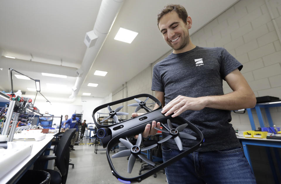 In this June 22, 2018, photo, Adam Bry, founder and CEO of Skydio, holds the R1 flying camera drone while being interviewed in Redwood City, Calif. Skateboarders, surfers and YouTube stars used to be the target customers for California drone startup Skydio, which builds sophisticated self-flying machines that can follow people around and capture their best moves on video. Now it's police officers and soldiers getting equipped with the pricey drones. U.S. political and security concerns about the world's dominant consumer drone-maker, China-based DJI, have opened the door for Skydio and other companies to pitch their drones for government and business customers. (AP Photo/Jeff Chiu)