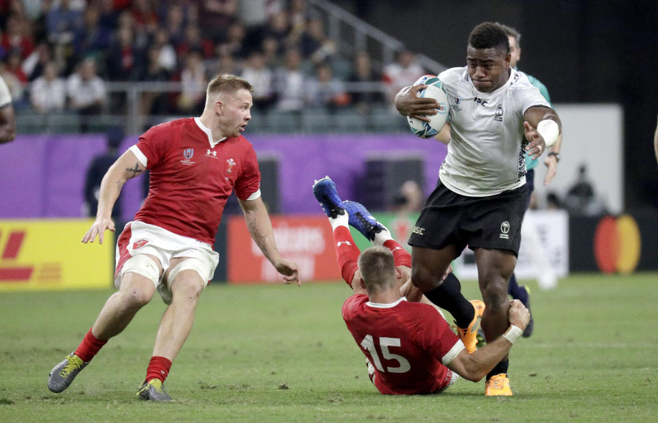 Fiji's Josua Tuisova is tackled by Wales' Liam Williams during the Rugby World Cup Pool D game at Oita Stadium between Wales and Fiji in Oita, Japan, Wednesday, Oct. 9, 2019. (AP Photo/Aaron Favila)