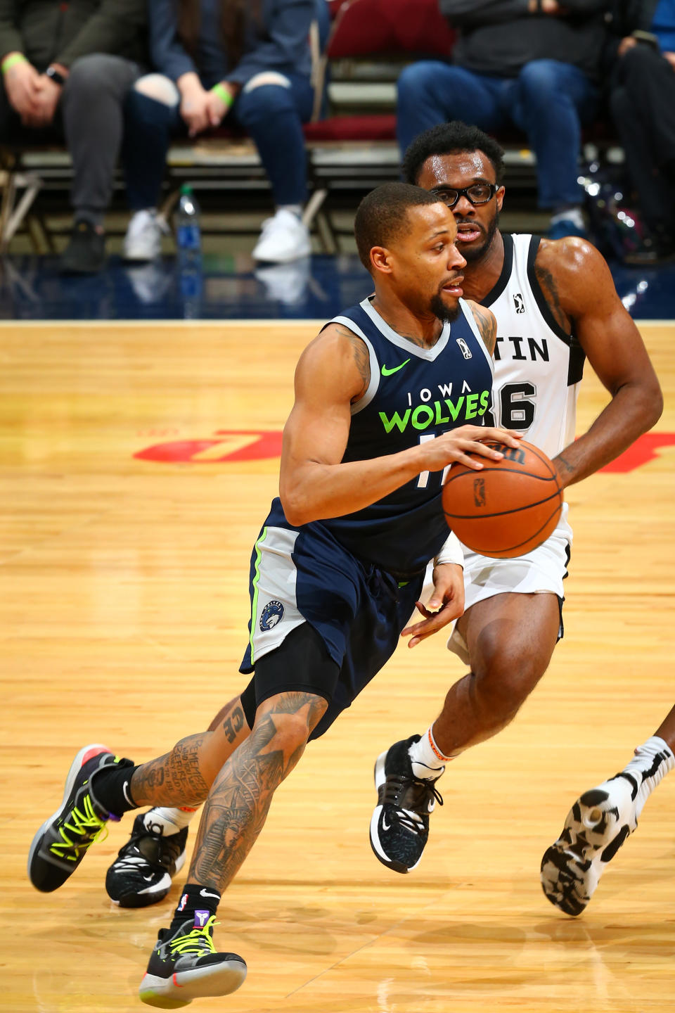 Isiah Briscoe dribbles past defense on a basetkball court.