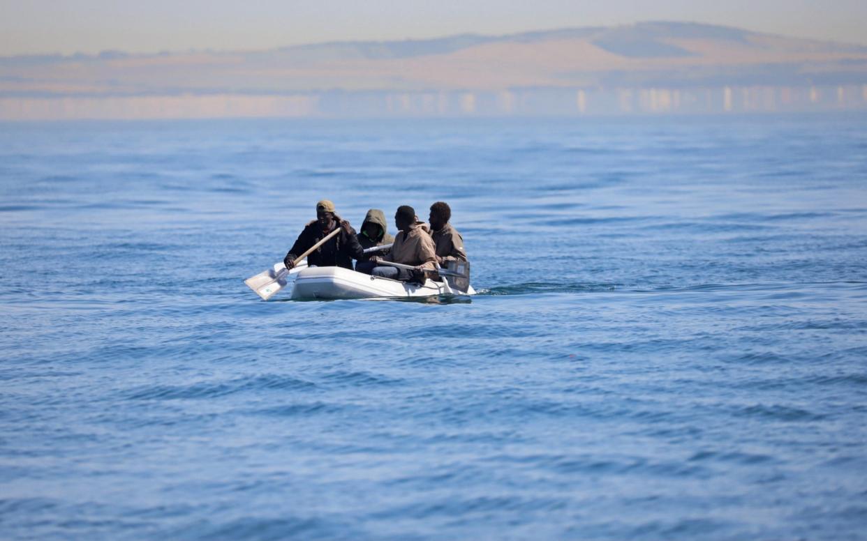 Four men, some using shovels as paddles, use a small dinghy to cross the English Channel on August 7, 2020 - GETTY IMAGES