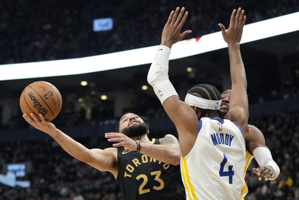 Toronto Raptors guard Fred VanVleet (23) tries for the layup under pressure from Golden State Warriors guard Moses Moody (4) and Golden State Warriors forward Jonathan Kuminga during the first half of an NBA basketball game in Toronto, Sunday, Dec. 18, 2022. (Frank Gunn/The Canadian Press via AP)